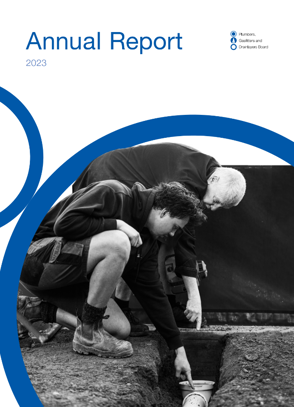 image of annual report cover featuring two people inspecting drainlaying for education purposes